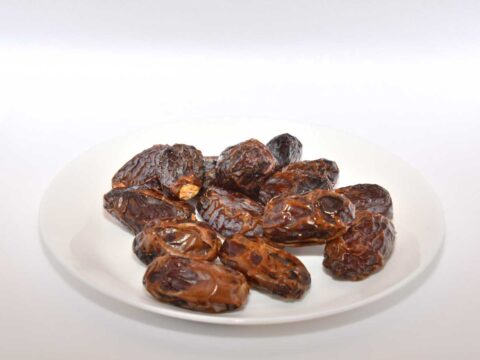 Gedroogde megjoul dadels op een wit schaaltje.